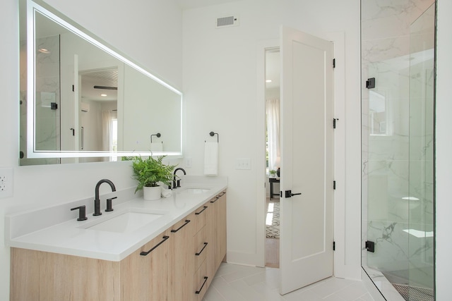 bathroom with tile patterned flooring, vanity, and a shower with shower door