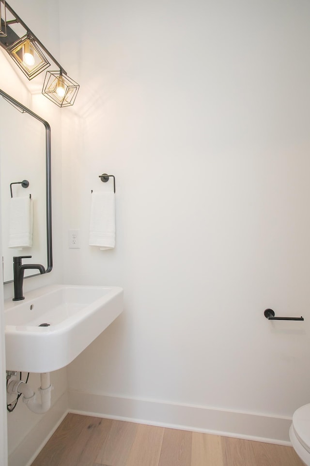 bathroom featuring hardwood / wood-style flooring, sink, and toilet