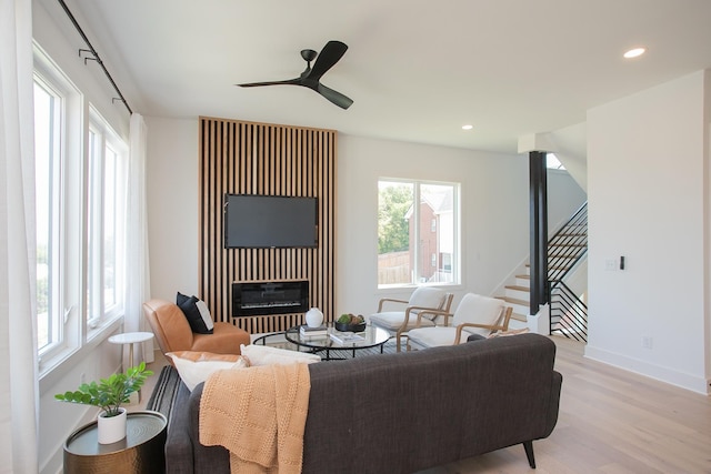 living room with ceiling fan, light hardwood / wood-style floors, and a wealth of natural light