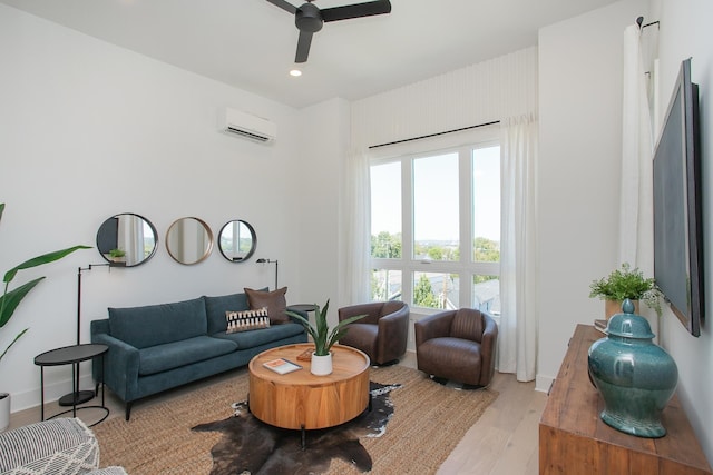 living room with light hardwood / wood-style flooring, ceiling fan, and a wall unit AC