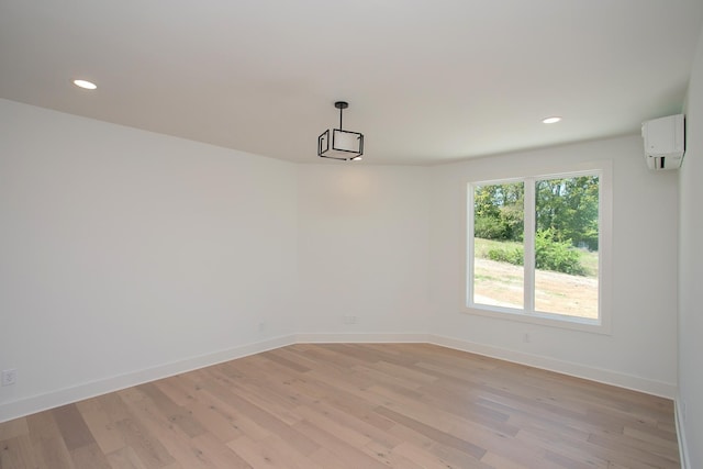 empty room with light hardwood / wood-style flooring and a wall mounted AC