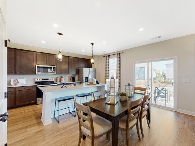 dining room with sink and light hardwood / wood-style floors