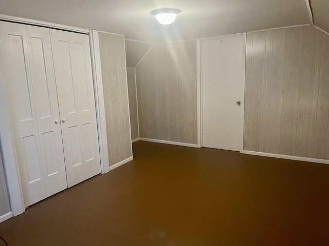 additional living space featuring wood walls and lofted ceiling