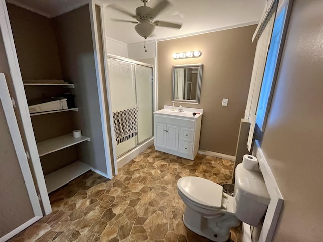 bathroom with vanity, ceiling fan, toilet, and a shower with door