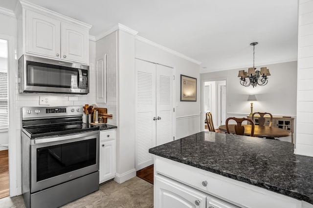 kitchen featuring hanging light fixtures, appliances with stainless steel finishes, a chandelier, white cabinets, and ornamental molding