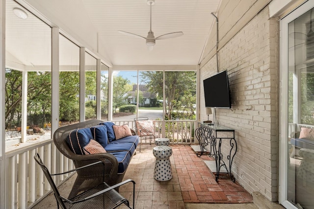 sunroom with a healthy amount of sunlight, ceiling fan, and lofted ceiling