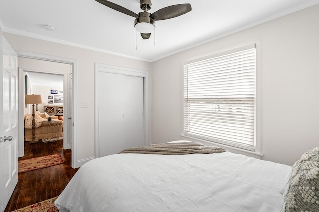 bedroom featuring dark hardwood / wood-style flooring, ceiling fan, a closet, and crown molding