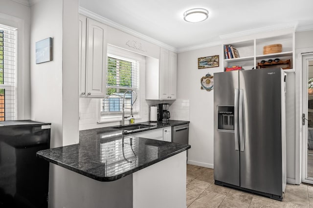 kitchen with white cabinets, stainless steel fridge, kitchen peninsula, and tasteful backsplash