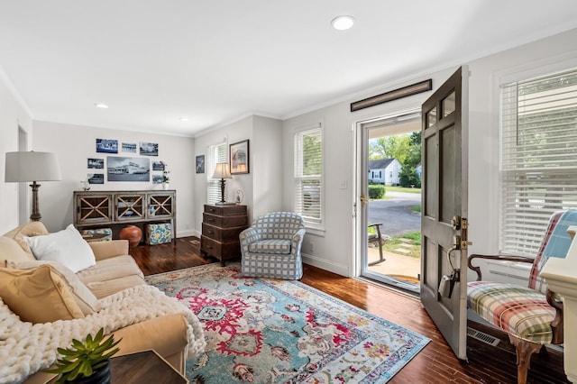 living room with dark hardwood / wood-style flooring, plenty of natural light, and crown molding