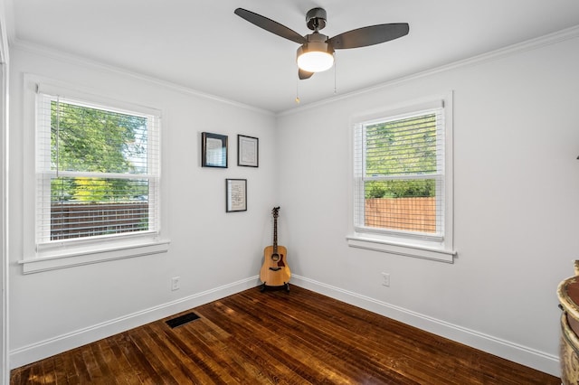 spare room featuring a wealth of natural light, crown molding, ceiling fan, and dark hardwood / wood-style floors