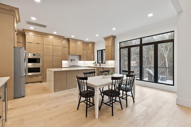 dining room with light hardwood / wood-style floors and a wealth of natural light