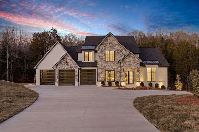 view of front of house featuring a garage and a lawn