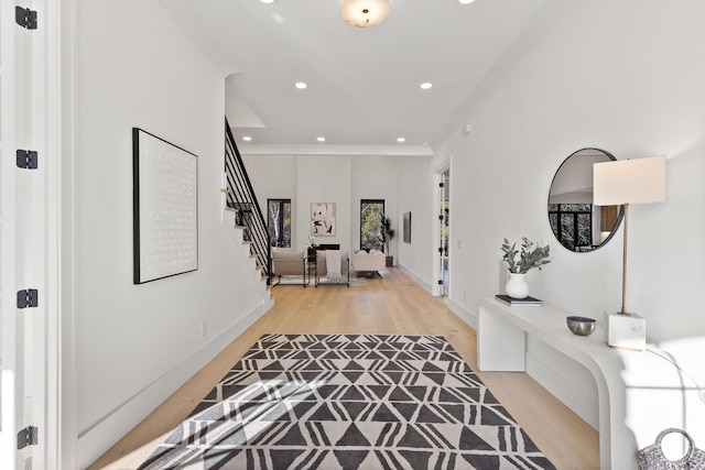 foyer entrance featuring light hardwood / wood-style flooring and ornamental molding