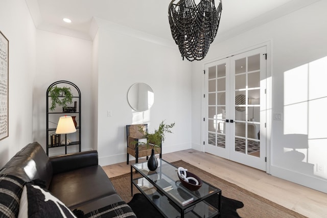 living room with french doors, ornamental molding, and wood-type flooring