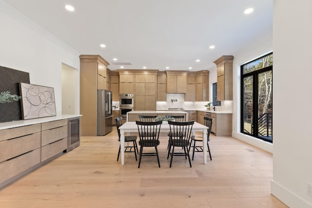 dining space featuring wine cooler and light wood-type flooring