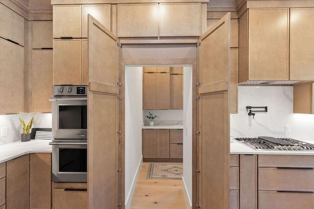 kitchen with light hardwood / wood-style flooring, stainless steel appliances, and light brown cabinets