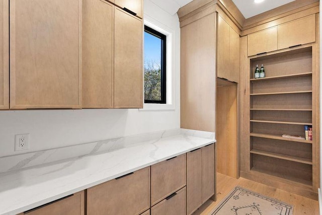 kitchen featuring light stone counters, light brown cabinetry, and light hardwood / wood-style flooring