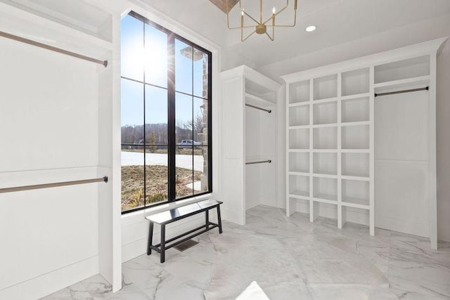 spacious closet featuring a notable chandelier