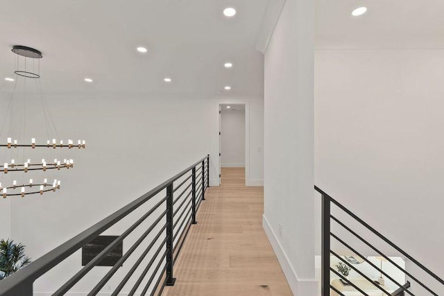 hall featuring a chandelier and light hardwood / wood-style floors