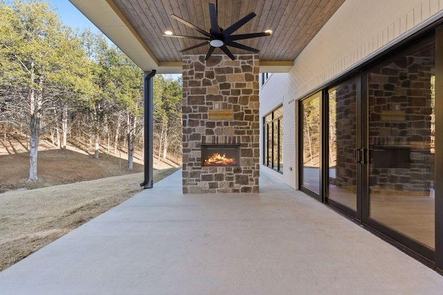 view of patio with ceiling fan and an outdoor stone fireplace