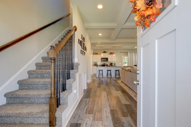 foyer entrance featuring beamed ceiling, light hardwood / wood-style floors, and coffered ceiling