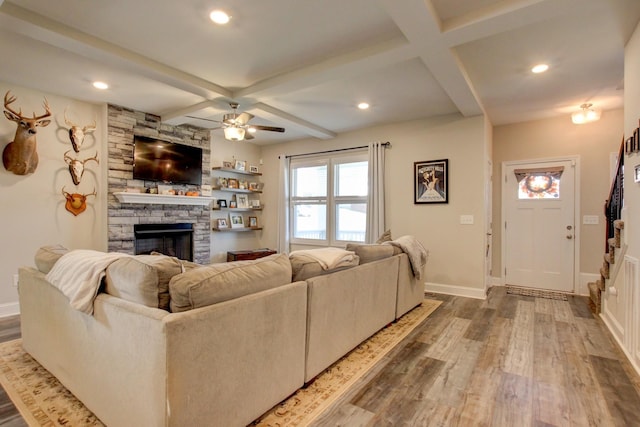 living room featuring beam ceiling, ceiling fan, coffered ceiling, a fireplace, and hardwood / wood-style flooring