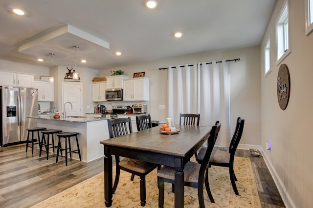 dining room with light wood-type flooring and sink