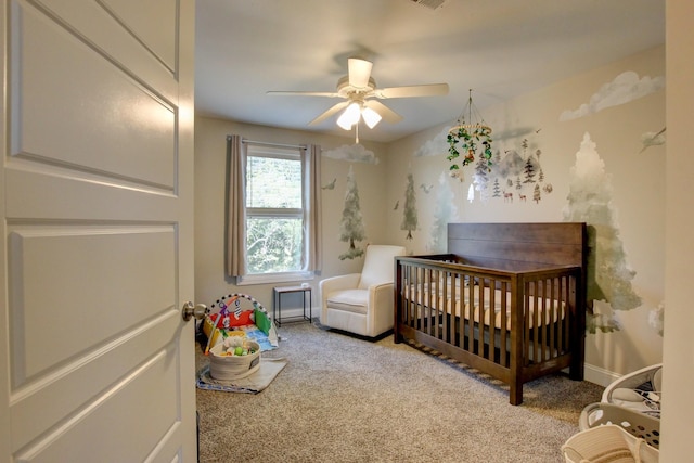 carpeted bedroom with ceiling fan and a crib