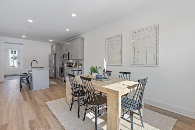 dining area with sink and light wood-type flooring