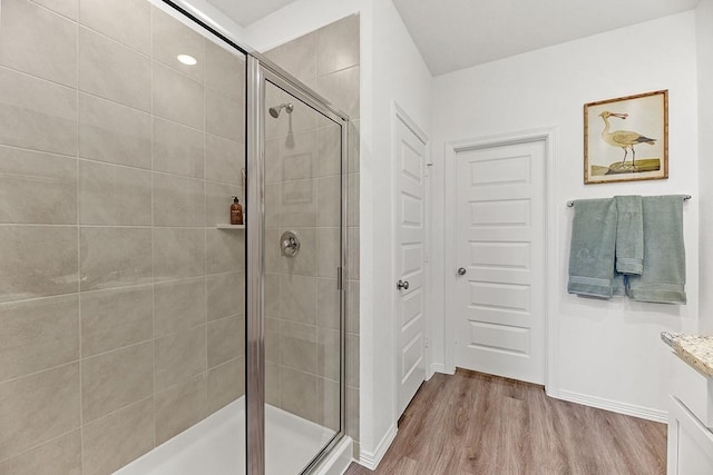 bathroom featuring a shower with door and wood-type flooring