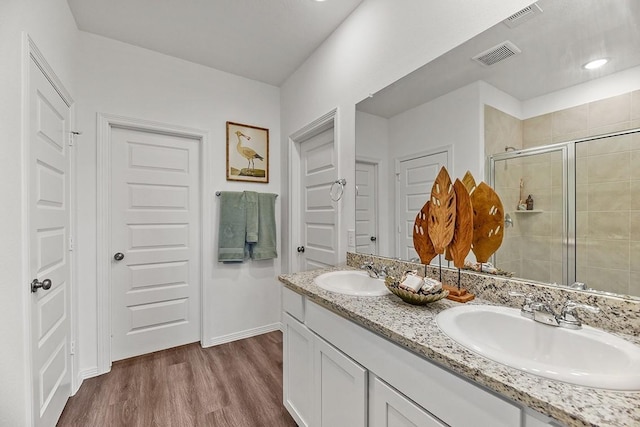 bathroom featuring vanity, wood-type flooring, and a shower with shower door