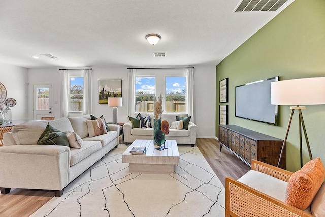 living room featuring a textured ceiling and light wood-type flooring