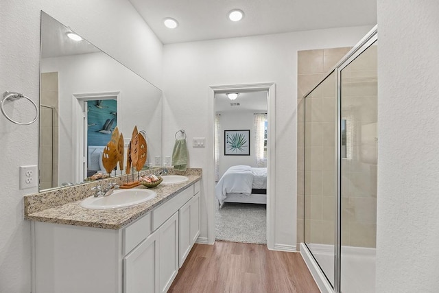 bathroom with hardwood / wood-style floors, vanity, and an enclosed shower