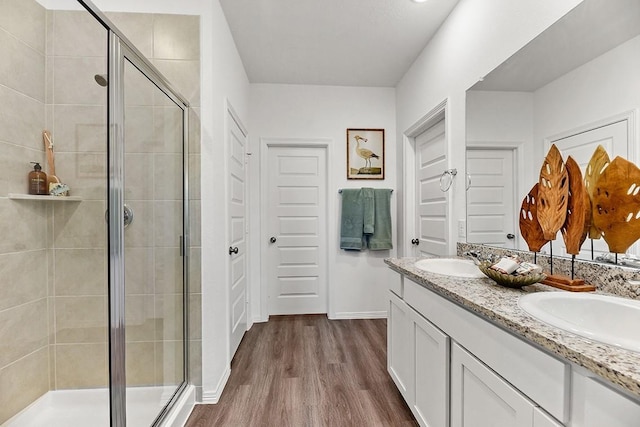 bathroom with wood-type flooring, vanity, and an enclosed shower