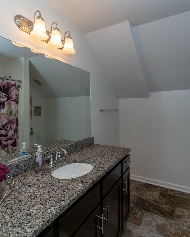 bathroom with vanity and vaulted ceiling