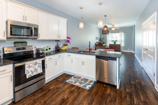 kitchen with sink, ceiling fan, decorative light fixtures, kitchen peninsula, and stainless steel appliances