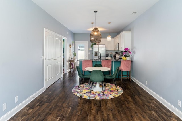 dining space featuring dark hardwood / wood-style flooring and sink