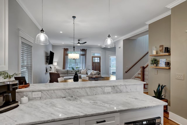 kitchen with light stone counters, white cabinets, and pendant lighting