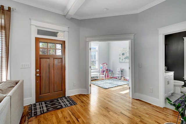 entrance foyer featuring beamed ceiling, light hardwood / wood-style flooring, a healthy amount of sunlight, and crown molding