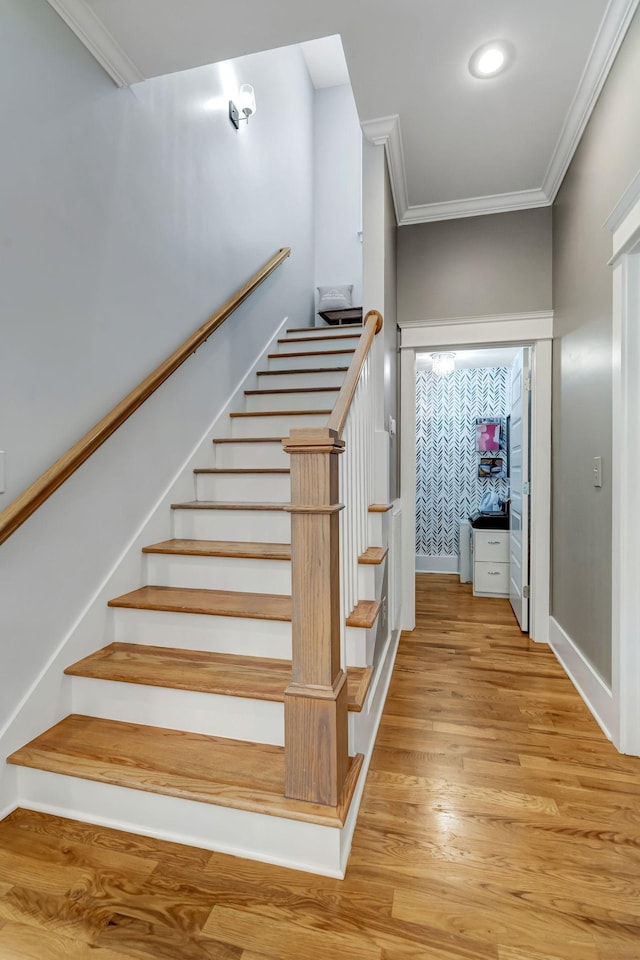 stairway with hardwood / wood-style flooring and ornamental molding