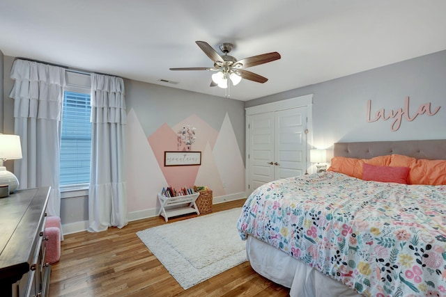 bedroom featuring ceiling fan, a closet, and hardwood / wood-style flooring