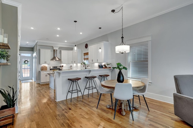 dining area with light hardwood / wood-style floors, sink, and crown molding