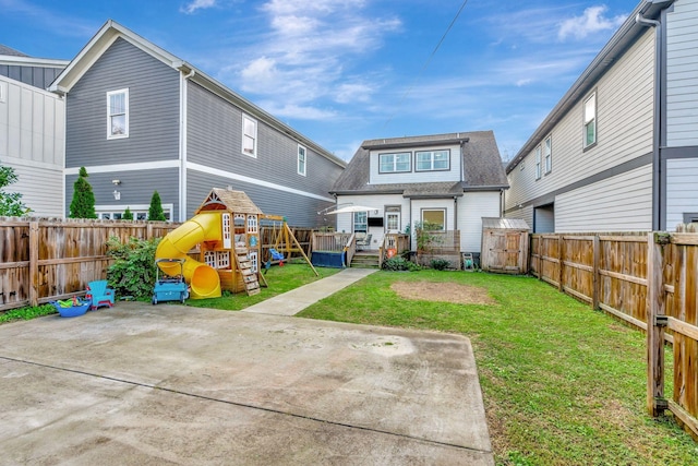 back of property featuring a playground, a yard, and a patio