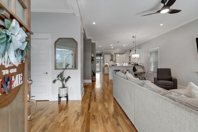 living room featuring ceiling fan, crown molding, and light hardwood / wood-style floors