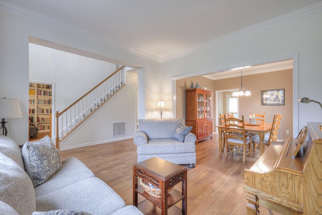 living room featuring wood-type flooring, an inviting chandelier, and crown molding