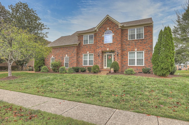 colonial inspired home with a front lawn