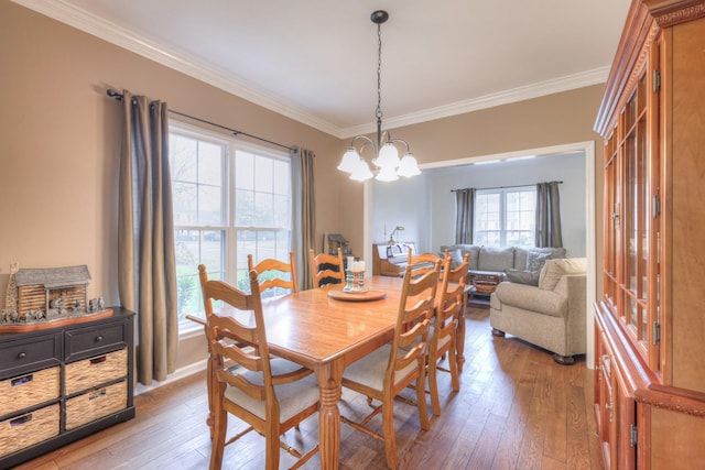 dining area featuring a chandelier, ornamental molding, and light hardwood / wood-style flooring