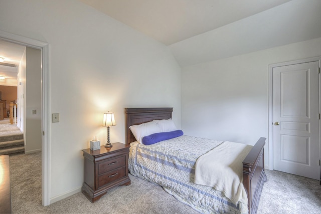 bedroom featuring light colored carpet and lofted ceiling