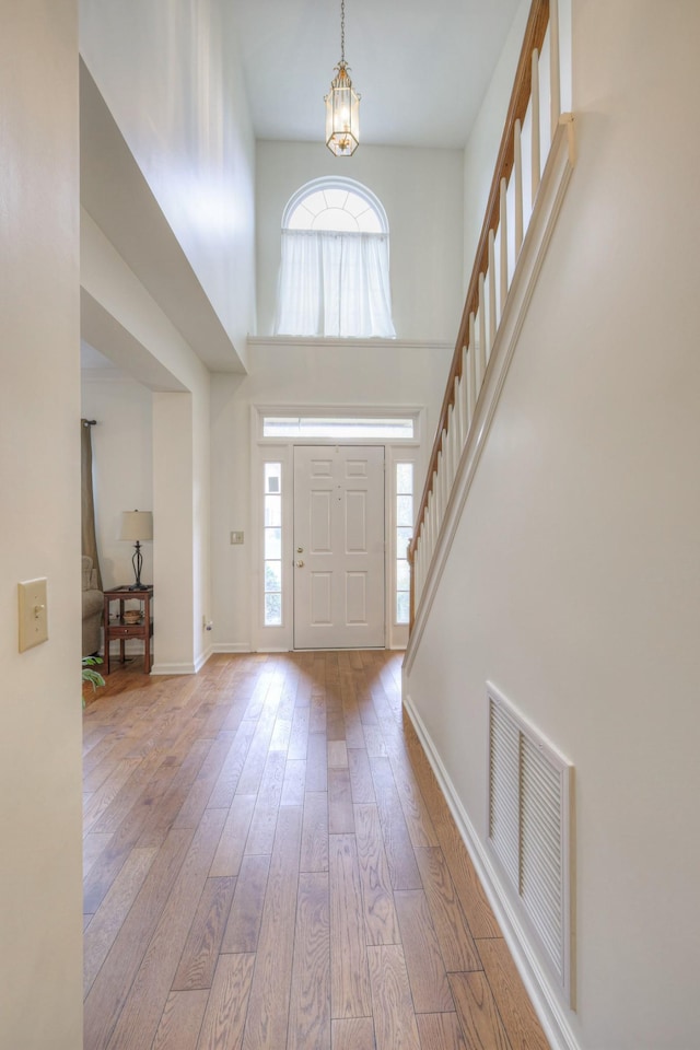 entrance foyer featuring hardwood / wood-style floors and a towering ceiling