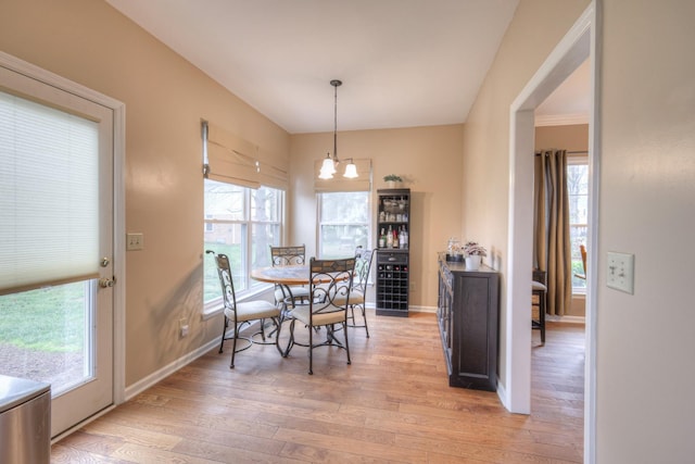 dining space featuring a chandelier, a wealth of natural light, and light hardwood / wood-style flooring